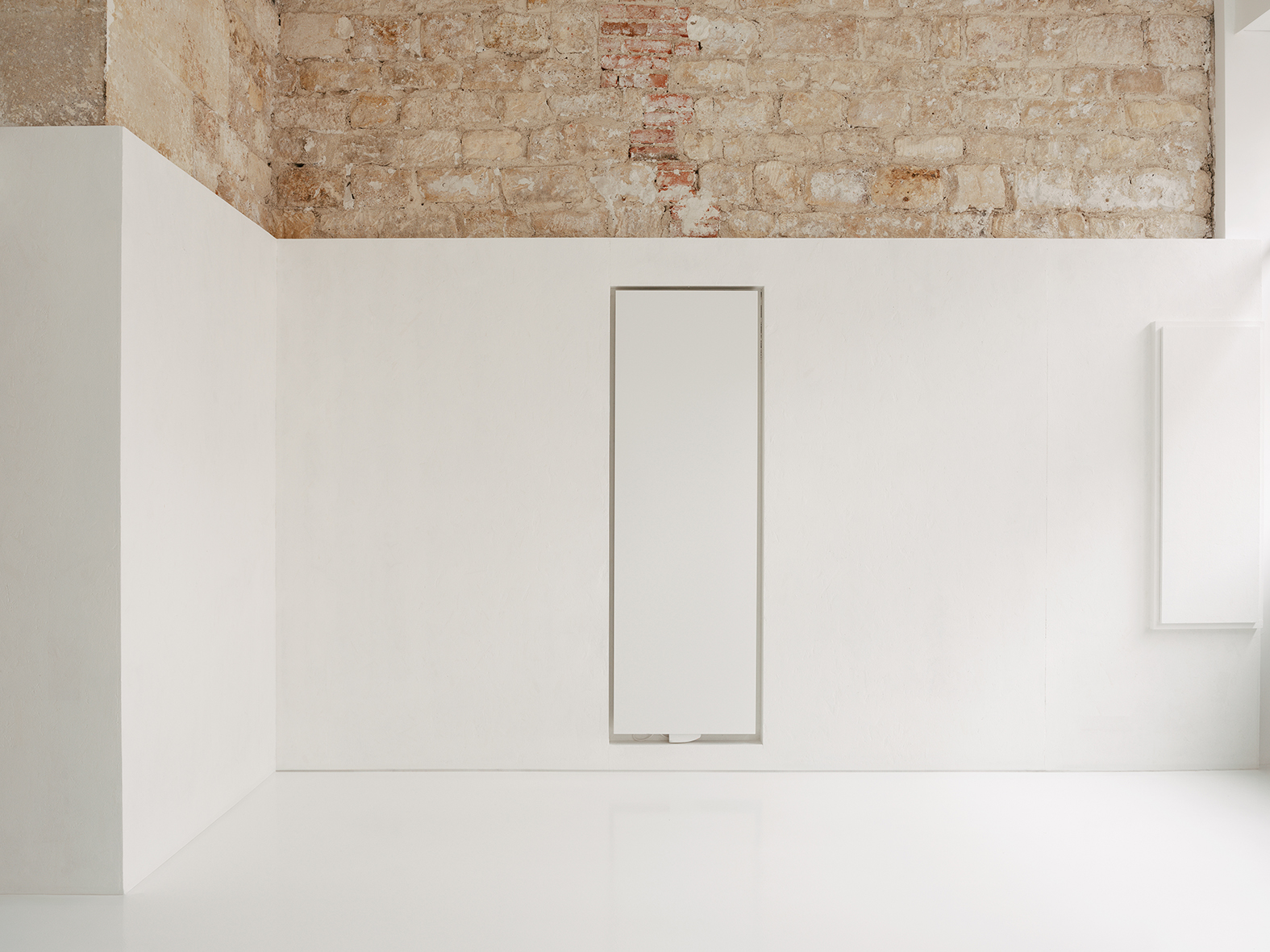 Détail d'un radiateur intégré dans la maçonnerie apparente